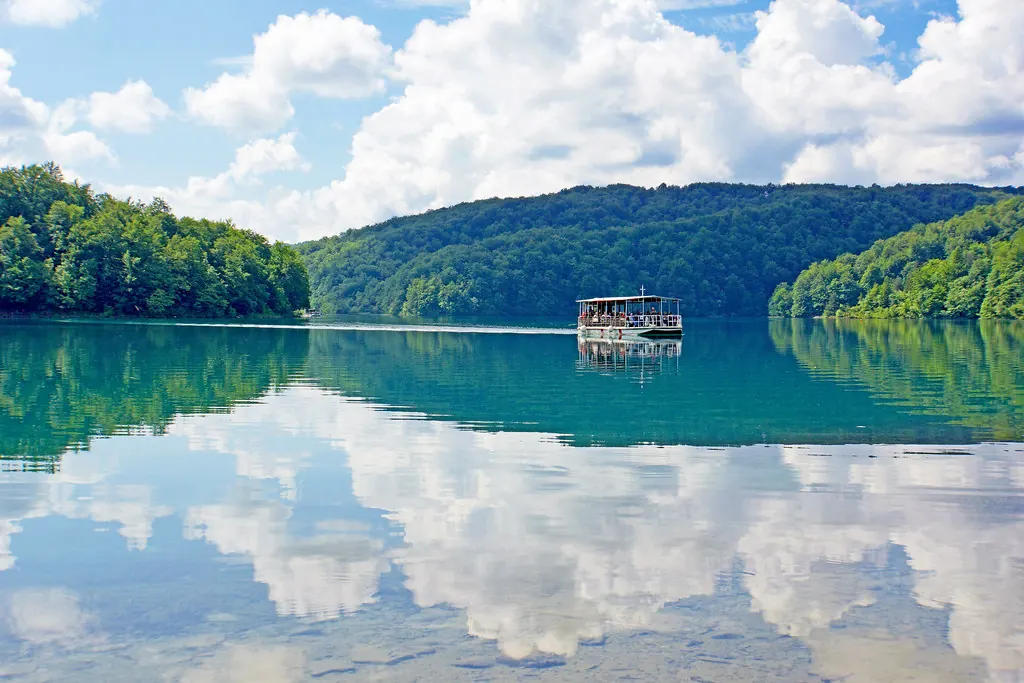 Lago tranquilo rodeado de bosque verde en un día soleado